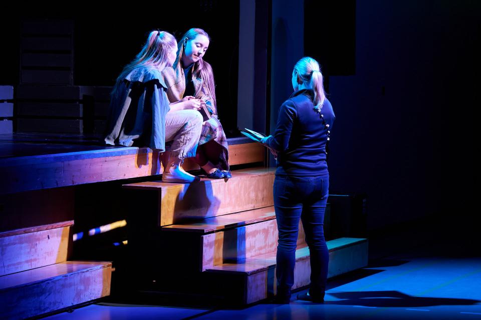 Valokuvassa Sotungin lukioteatteriesityksen "Saiturin joulu" ohjaaja antaa viimeisiä ohjeita näyttelijöille ennen läpimenoa.